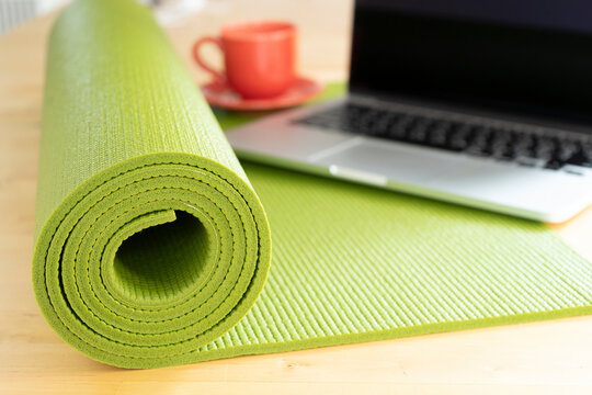 close up of green yoga mat on the table, sport and healthy and work out at office concept