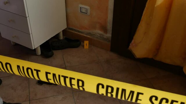 csi investigator at the crime scene who inspects with blue flashlights and takes scientific evidence to take to the laboratory taken from the handle of a house door where a murder was committed