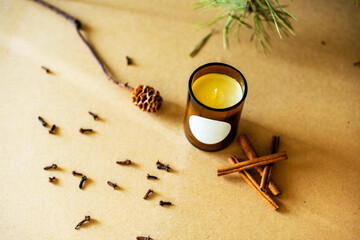 Handmade candle from paraffin and soy wax in glass with flowers and leaf on craft background. Let...