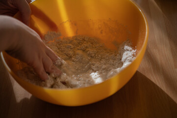 Close up of feminine hands mixing flour and water to make dough