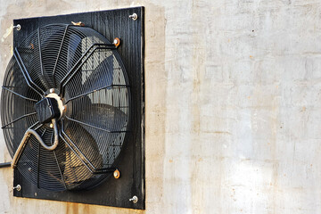 Big industrial fan in a white brick wall of a factory. Ventilation of factory building outdoors.