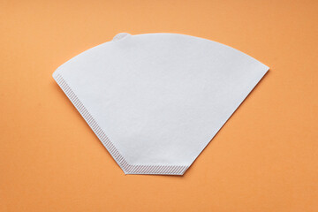 Bleached paper coffee filter for immersion brewing isolated on a colored pink background....