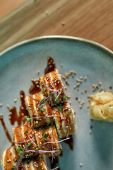 Close up of tasty fresh sushi roll set with unagi and sesame decorated and served on a plate