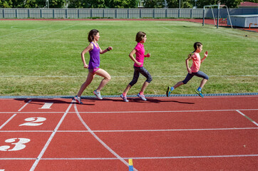 Family fitness, mother and kids running on stadium track, exercise with children  and sport healthy lifestyle concept
