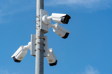 Security systems and alarm technology concept: Many CCTV cameras hanging on an outdoor pole and...