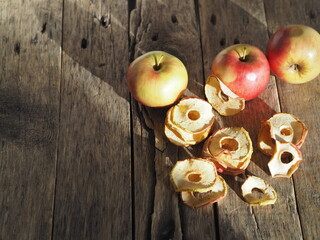 Autumn. Homemade dried fruit apple chips with fresh apples on a rustic wooden table.The benefits of dried fruit.