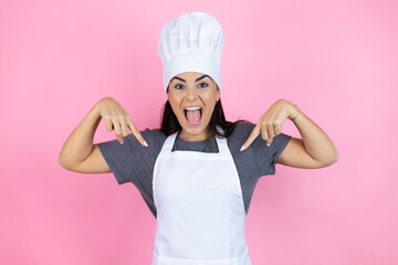 Young hispanic woman wearing baker uniform over pink background looking confident with smile on...