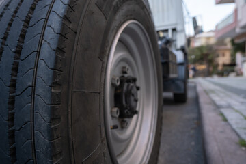 Fototapeta na wymiar rear right wheel of a truck parked near a sidewalk in city low angle view