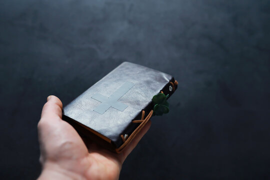 A leather-bound Bible on the table. Religious Christian Irish celebration. Four-leaf clover symbol of good luck.