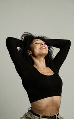 sitting on a chair in a photo studio, curly brunette black hair. the manager is a freelance student. positive playful sweet young beautiful confident woman of African appearance ethnics.