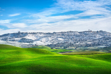 Fototapeta na wymiar Volterra snowy town and rolling hills in winter. Tuscany, Italy
