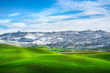 Fototapeta premium Volterra snowy town and rolling hills in winter. Tuscany, Italy