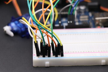 Science projects or electronics project concept shown by connecting jumper wires to breadboard with...
