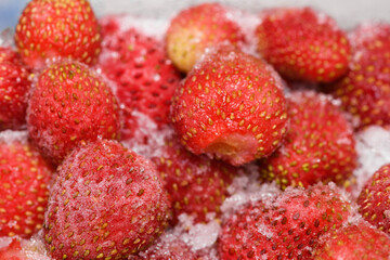 Frozen strawberries covered by frost, berry Victoria, close-up. Berry in ice