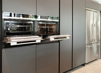 Modern kitchen with grey furniture, Black oven, Combination Microwave, Warming drawer built in tall cabinet.