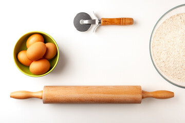 Bowl of  whole wheat flour and dough roller.