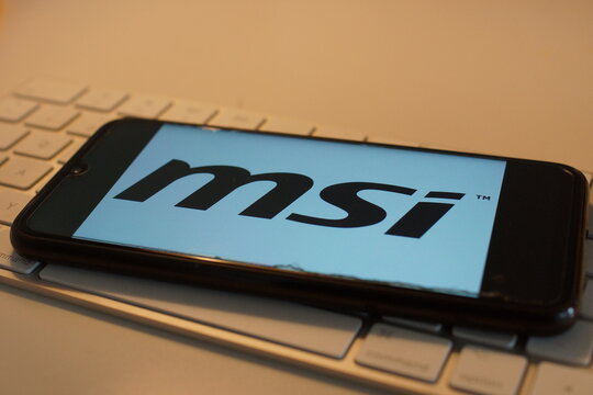 Leipzig, Germany - February 10, 2021: Closeup of smartphone screen with logo lettering of msi on computer keyboard (focus on center upper lettering)