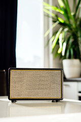 A vintage radio sits on a white table in the kitchen. Music is playing. They broadcast the morning...
