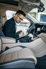 Car seller working in showroom and quality control checking of car details for the last time before buyer comes.