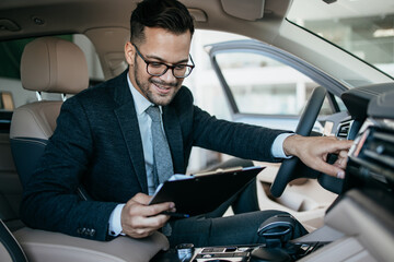 Car seller working in showroom and quality control checking of car details for the last time before buyer comes.