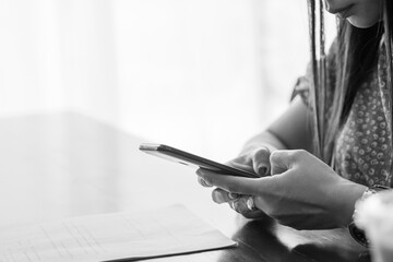 Young girl working with smartphone on wooden table.