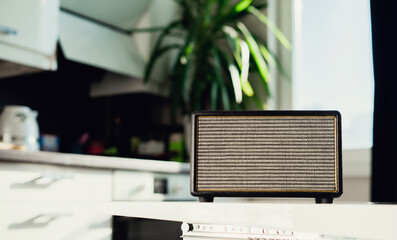 Music speaker. Radio receiver. A modern radio sits on a white table in the kitchen. Accepts the melody channel link.