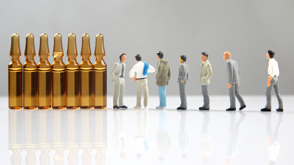 miniature people. people and medical ampoules on a white background.