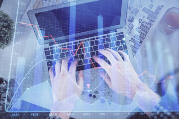 Fototapeta na wymiar Double exposure of man's hands typing over laptop keyboard and forex chart hologram drawing. Top view. Financial markets concept.