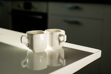 Morning light from the window. An invigorating drink instead of an energy drink. Ceramic cups of white light coffee. A hot, flavorful drink. Americano and espresso are on the table.