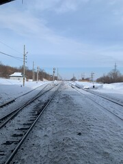 railroad tracks straight with snow in the outside of a small town