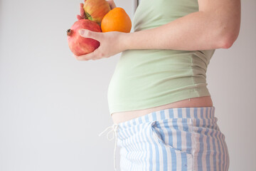 Pregnant girl eats fruits for a healthy diet and balanced nutrition. Fruit and raw foods during pregnancy. Healthy mother healthy baby
