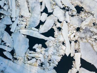 Ice melts on the river. Ice crack. Aerial drone view. Spring sunny morning.