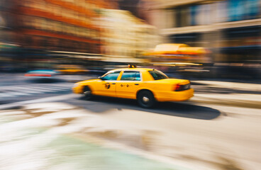 New York City - March 20, 2017 : Yellow taxi cab speeds down in a New York City Street. Shot with long shutter speed for intentional motion blur.