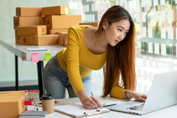 Start up successful small business owner, a freelance young Asian female merchant preparing a package box to deliver to customers, SME entrepreneurs, online business ideas, bloggers