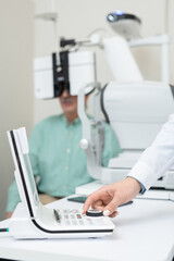 Hand of young contemporary ophthalmologist turning knob on examination equipment