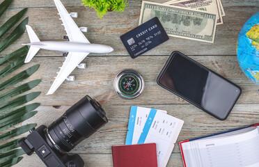 Documents, plane tickets and other travel supplies on a wooden background. Top view