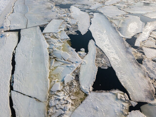 Ice melts on the river. Ice crack. Aerial drone view. Spring sunny morning.