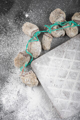 Dried persimmon fruits decorated with flour on black surface