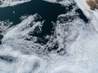 Ice melts on the river. Ice crack. Aerial drone view. Spring sunny morning.