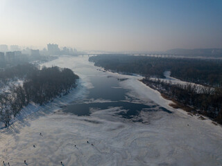 Melting Dnieper River in spring Kiev. Ice crack on the river. Aerial drone view. Spring sunny morning.
