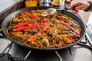 Close-up of a traditional Valencian Paella, cooked in a paella pan, with natural ingredients and...
