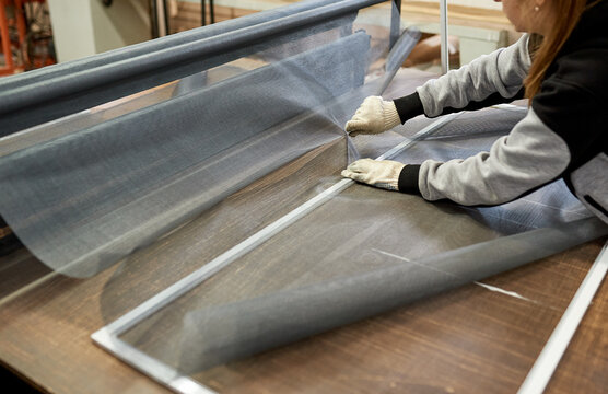 Shop for the production of mosquito nets. Close-up of a person's hands assembling the structure.