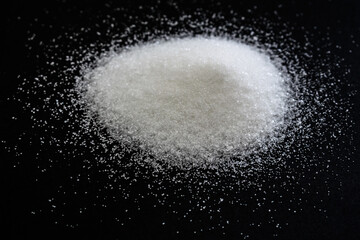 Obraz na płótnie Canvas heap of white sugar in black background