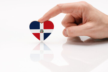 Dominican Republic flag. Love and respect to the Dominican Republic. A man's hand holds a heart in...