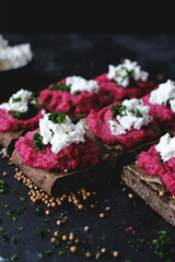 Obraz na płótnie Canvas Baked Beetroot Hummus on toasted bread. Dark background, selective focus. Vegan recipes, plant-based dishes. Green living concept. Organic food. Vegetarian cuisine. 
