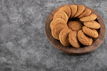 Homemade fresh cookies on wooden tray over grey background