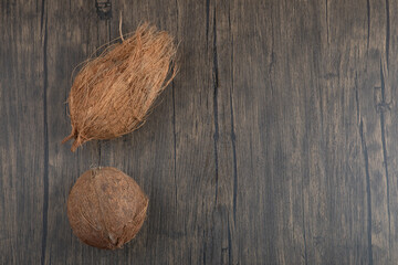 Two hairy hard coconut on wooden surface