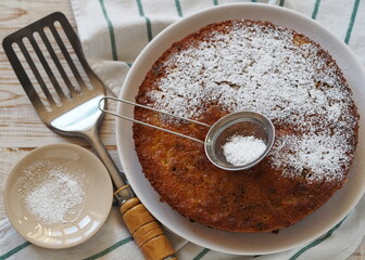 The process of making semolina pie with ingredients on a wooden background. Sprinkle cake with icing sugar. Food background.