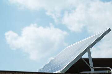 Small solar cell farming on the roof with blue sky background. Alternative energy for household...