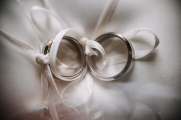 photo of two wedding rings on a small pillow